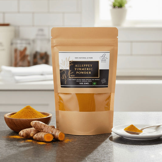 Angadi of Spices Authentic Alleppey Turmeric Powder in a resealable pouch with fresh turmeric roots and powder in a bowl.