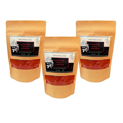 Angadi of Spices Kashmiri Chilli Powder in brown resealable pouches, 100g each, showing vibrant red powder.