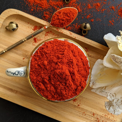 Angadi of Spices Kashmiri chilli powder in a decorative bowl and spoon, vibrant red hue, minimum pungency, rich in vitamins and iron.