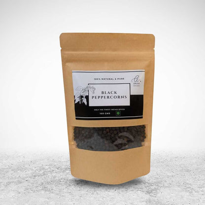 Angadi of Spices whole black peppercorns, TGSEB grade, 100g pouch with a clear window showcasing the bold, dark peppercorns.